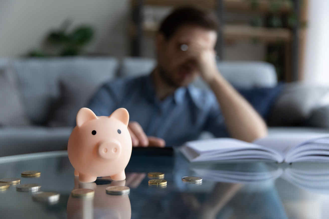 A man looking stressed counting his money