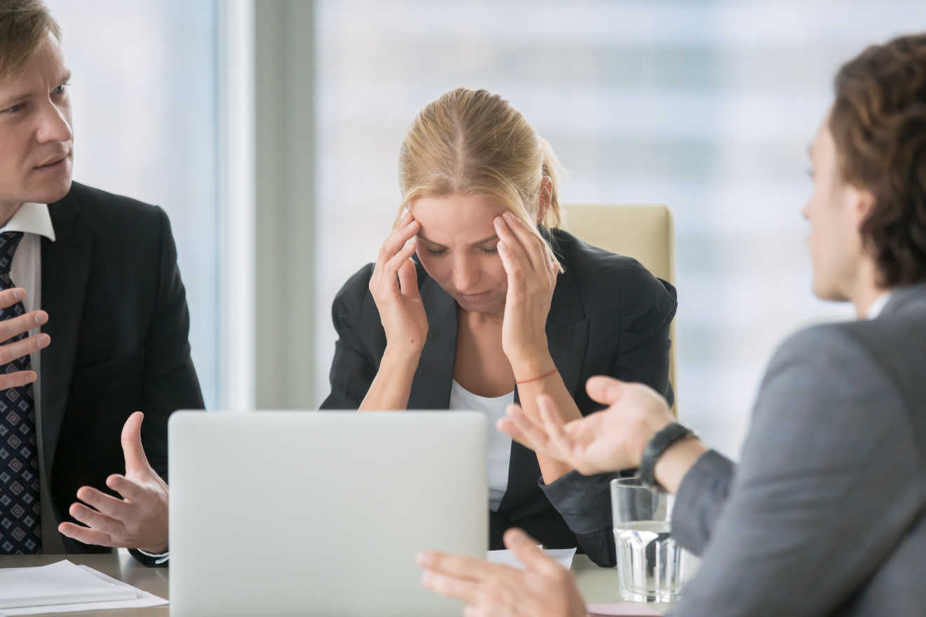 A woman at working looking stressed out in a meeting